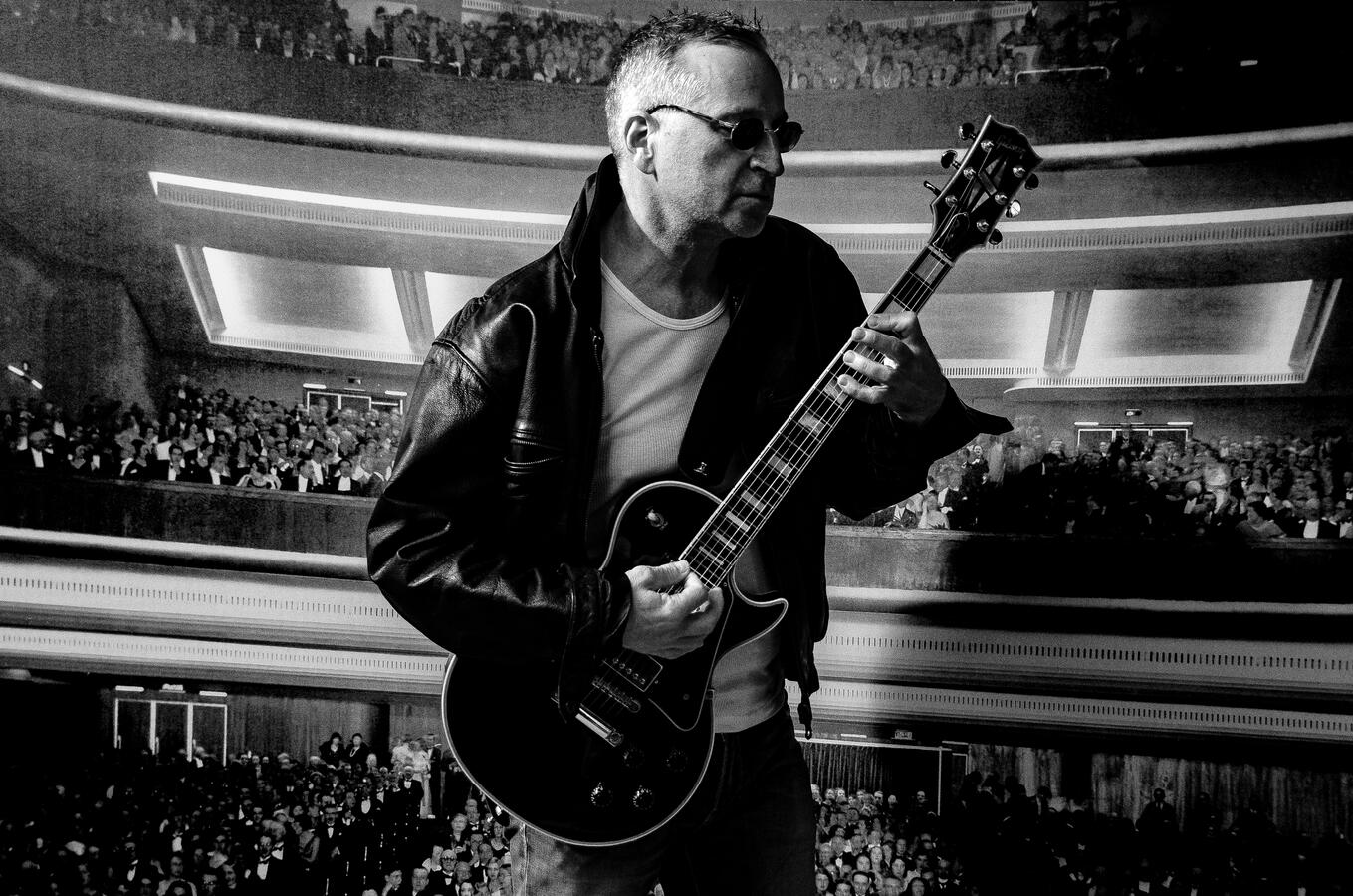 Candid black-and-white music portrait, guitarist in performance pose. Candid black-and-white music portrait, guitarist in performance pose.