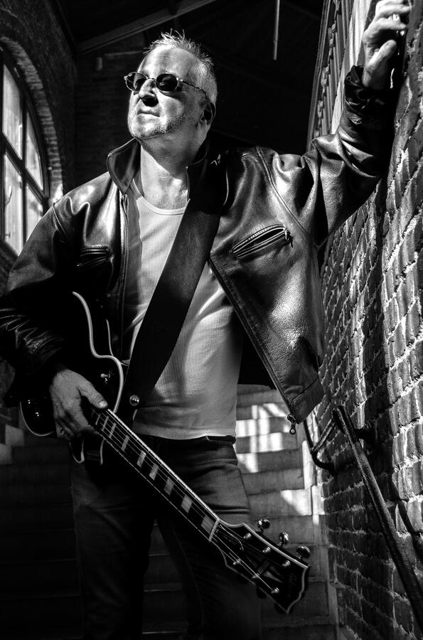 Black-and-white portrait of an independent rock musician with guitar. Black-and-white portrait of an independent rock musician with guitar.